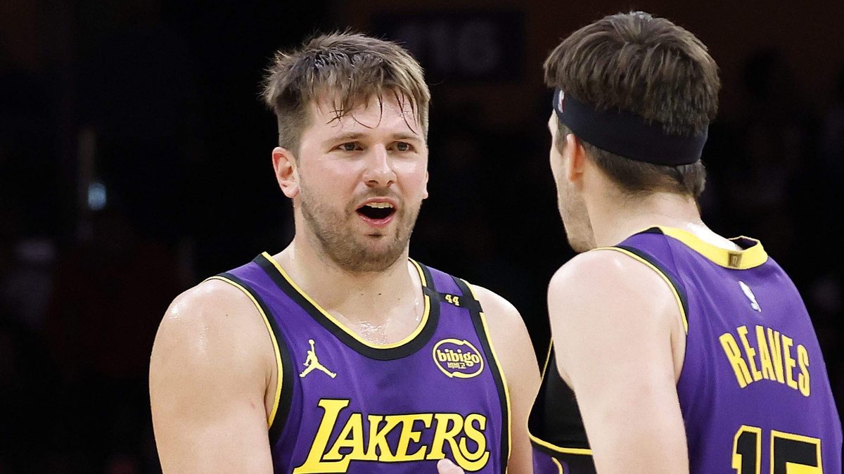 Luka Doncic talks with Austin Reaves in purple Lakers uniforms.
