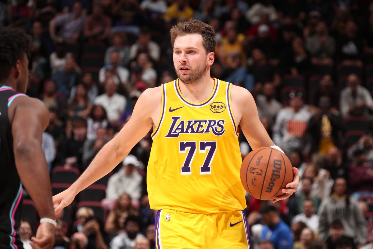 Luka Doncic, in a gold Lakers No. 77 jersey, brings the ball up the floor in Miami.