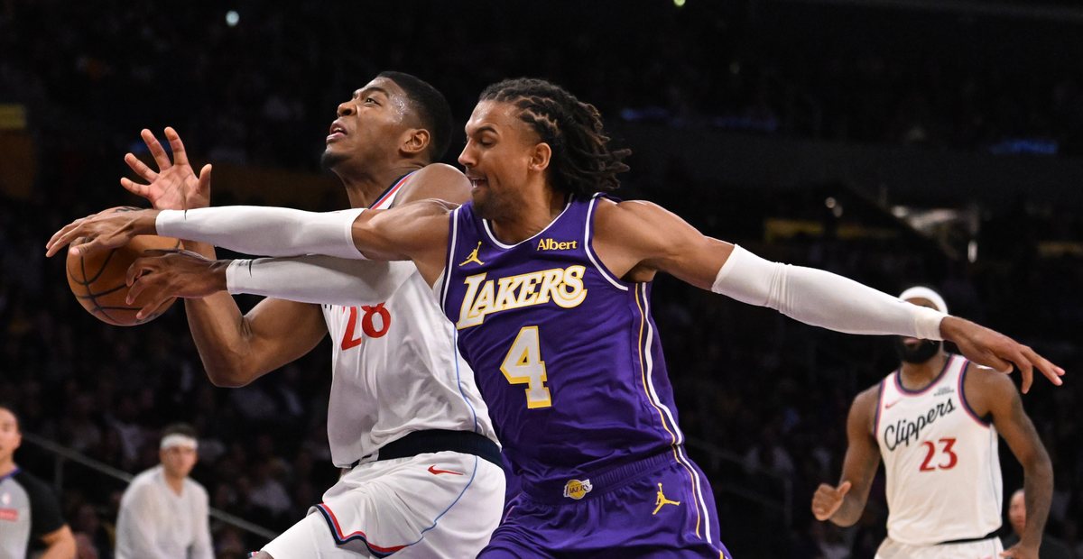 Matisse Thybulle reaches for the ball held by Rui Hachimura during Lakers-Clippers action.